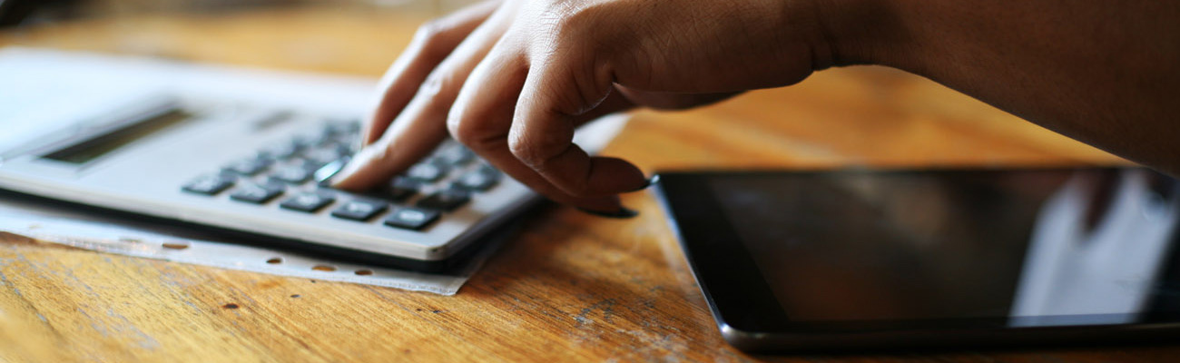 Close up shot of a woman's hand on a calculator.