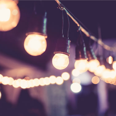 A string of globe lights glows in the night sky.