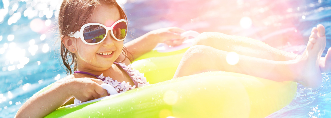 Young girl floating on a tube in a pool.