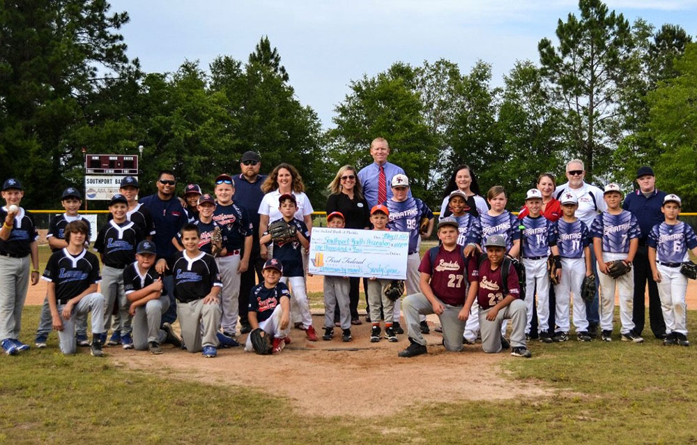 The Southport Youth Sports association stands in their baseball gear after receiving their check.