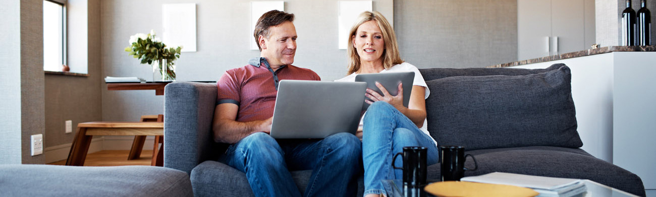 Couple on laptop sitting in a living room.