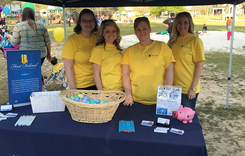 A group of First Federal employees stand together at a community event.