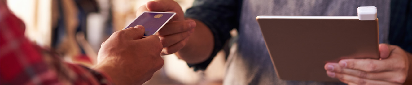 A young woman holds a debit card with gift bags on either side of her