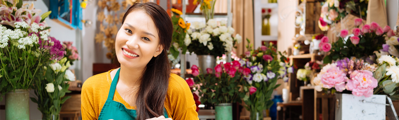 Asian woman in front of flower shop.