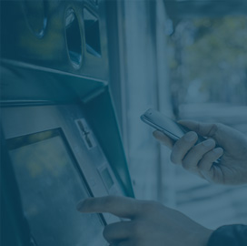 Close up of a person using an ATM.