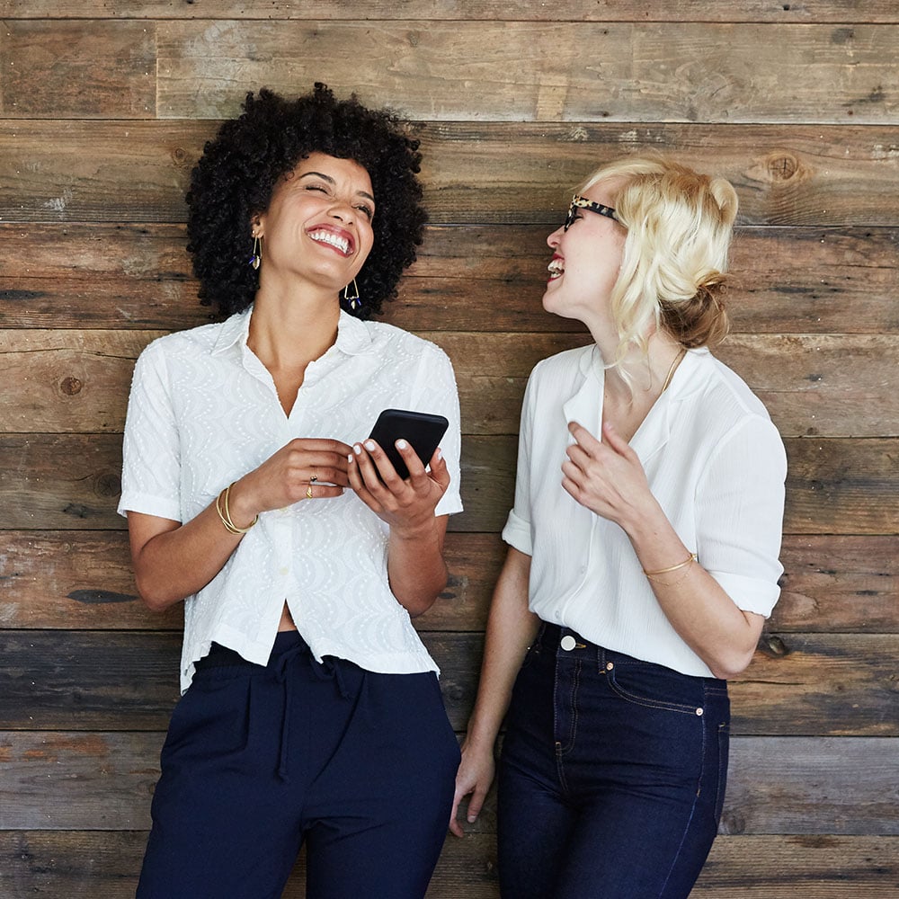 two women using zelle on phone