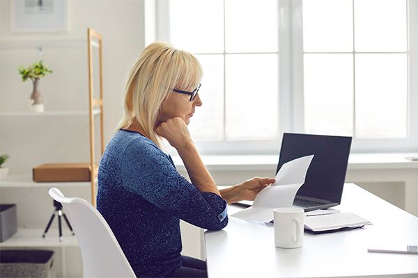 woman on laptop looking at documents